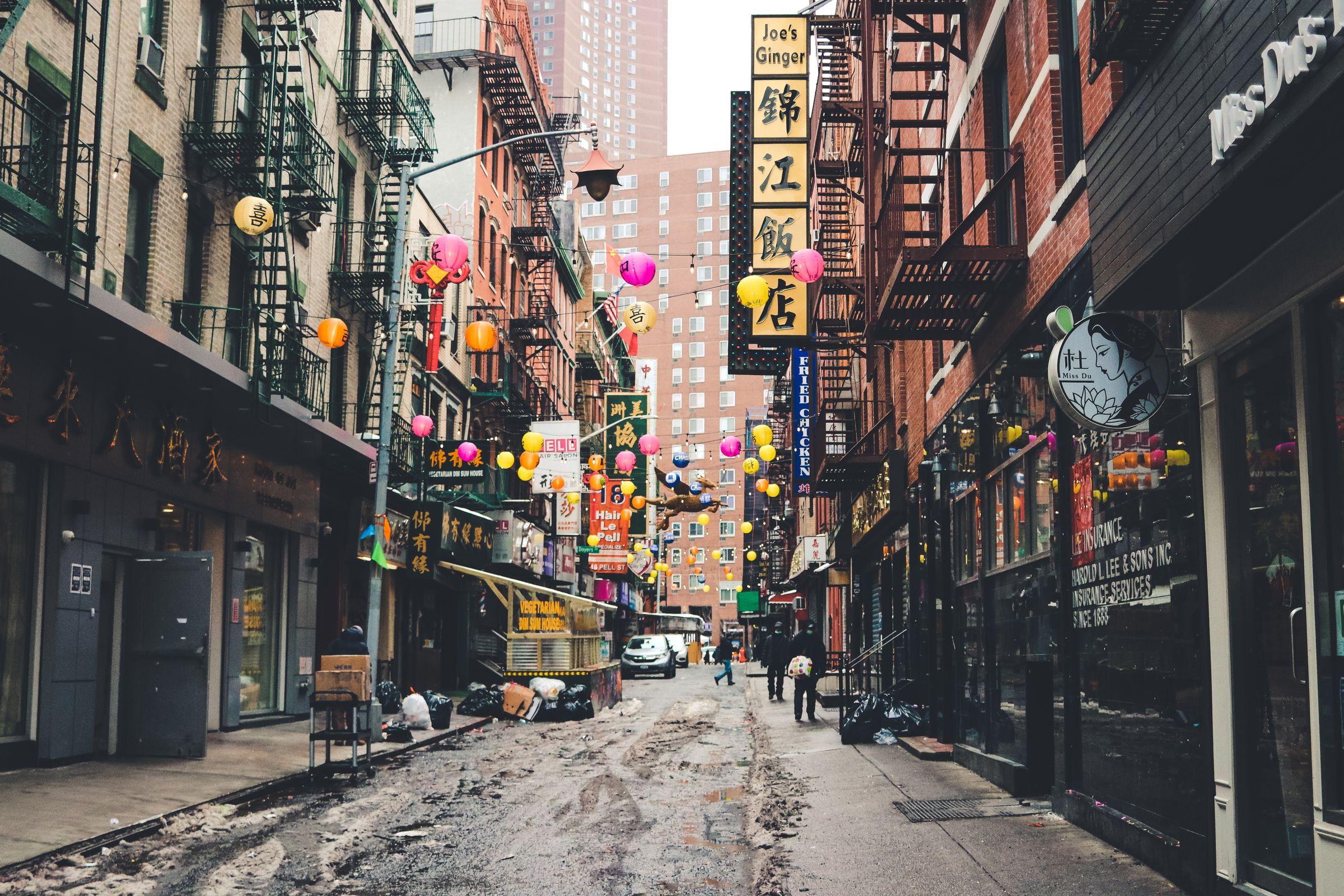 Tenement buildings with fire escapes on a narrow downtown street