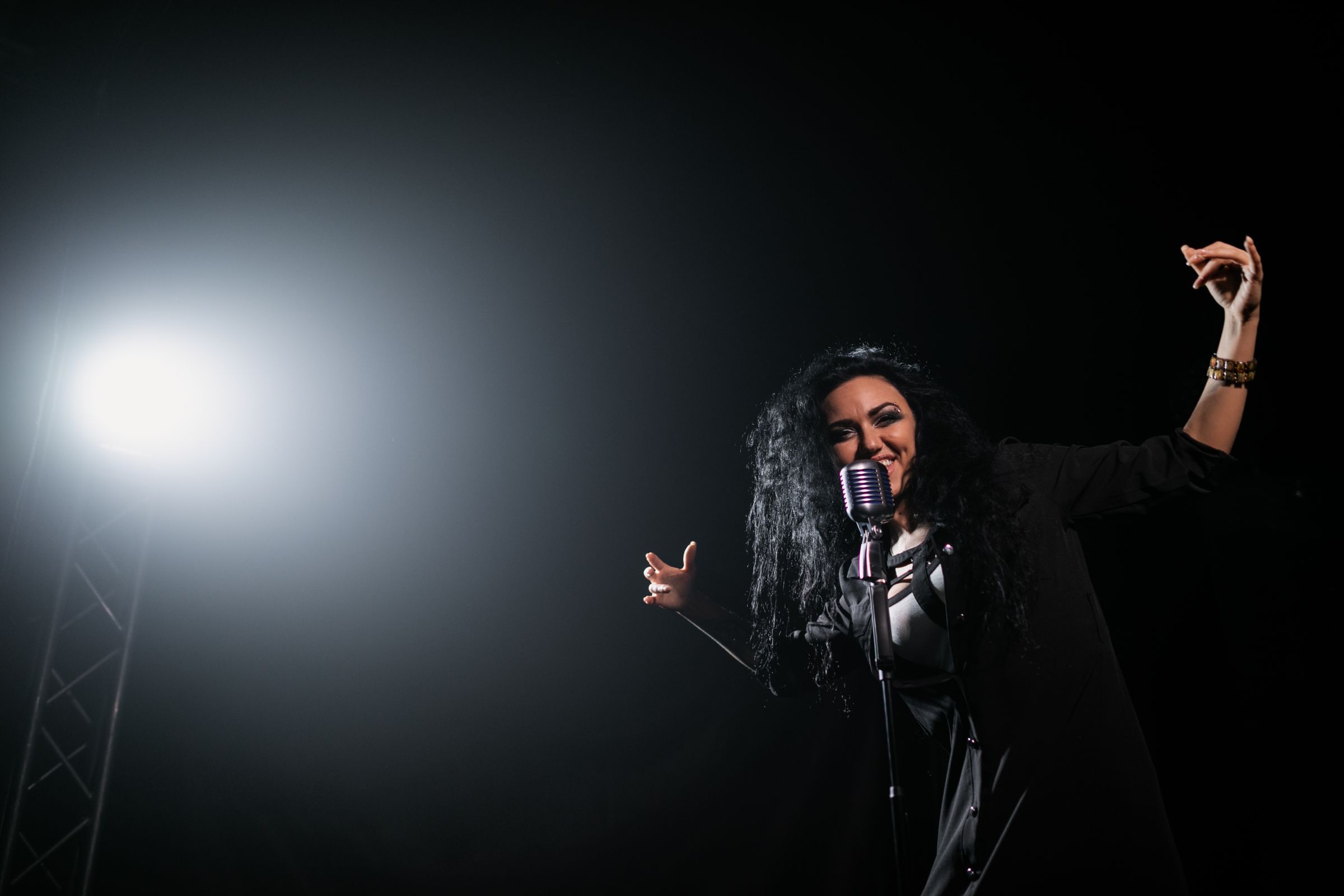 A singer in a spotlight on a dark stage