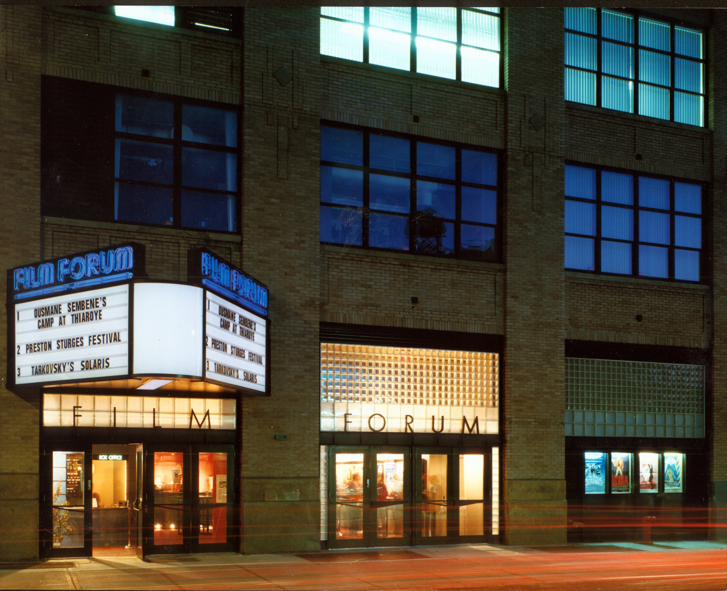 Film Forum's marquee and glass-block entrance on West Houston Street at dusk