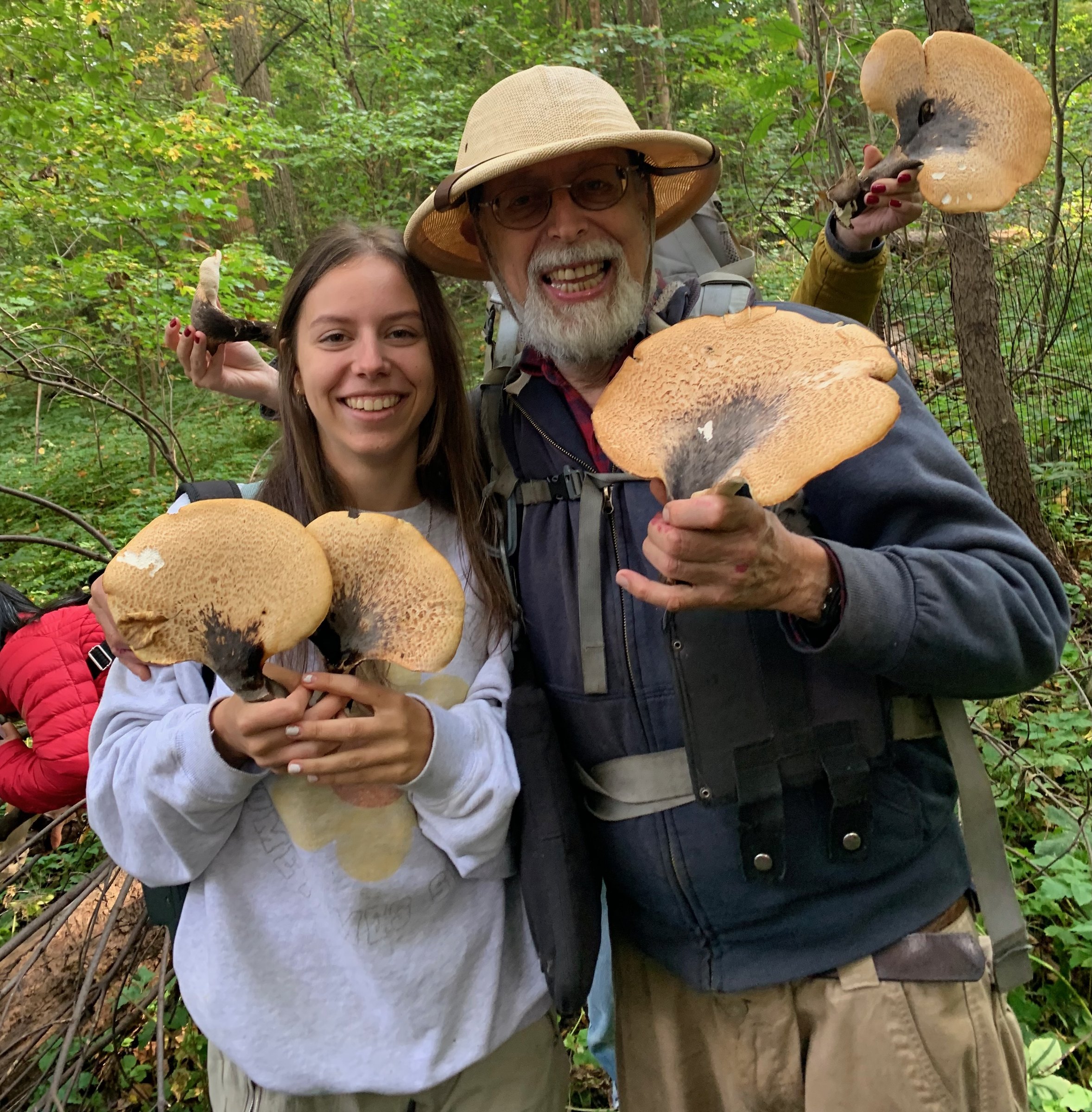"Wildman" Steve Brill and his daughter Violet holding wild mushrooms in the woods