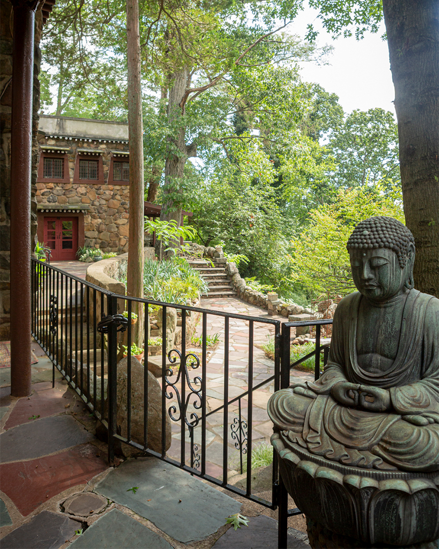 A bronze Buddha by the garden gate at the Jacques Marchais Museum of Tibetan Art on Lighthouse Hill