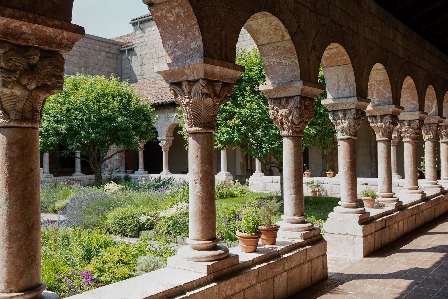 The arcade of the Cuxa Cloister at The Met Cloisters, its carved capitals framing the garden