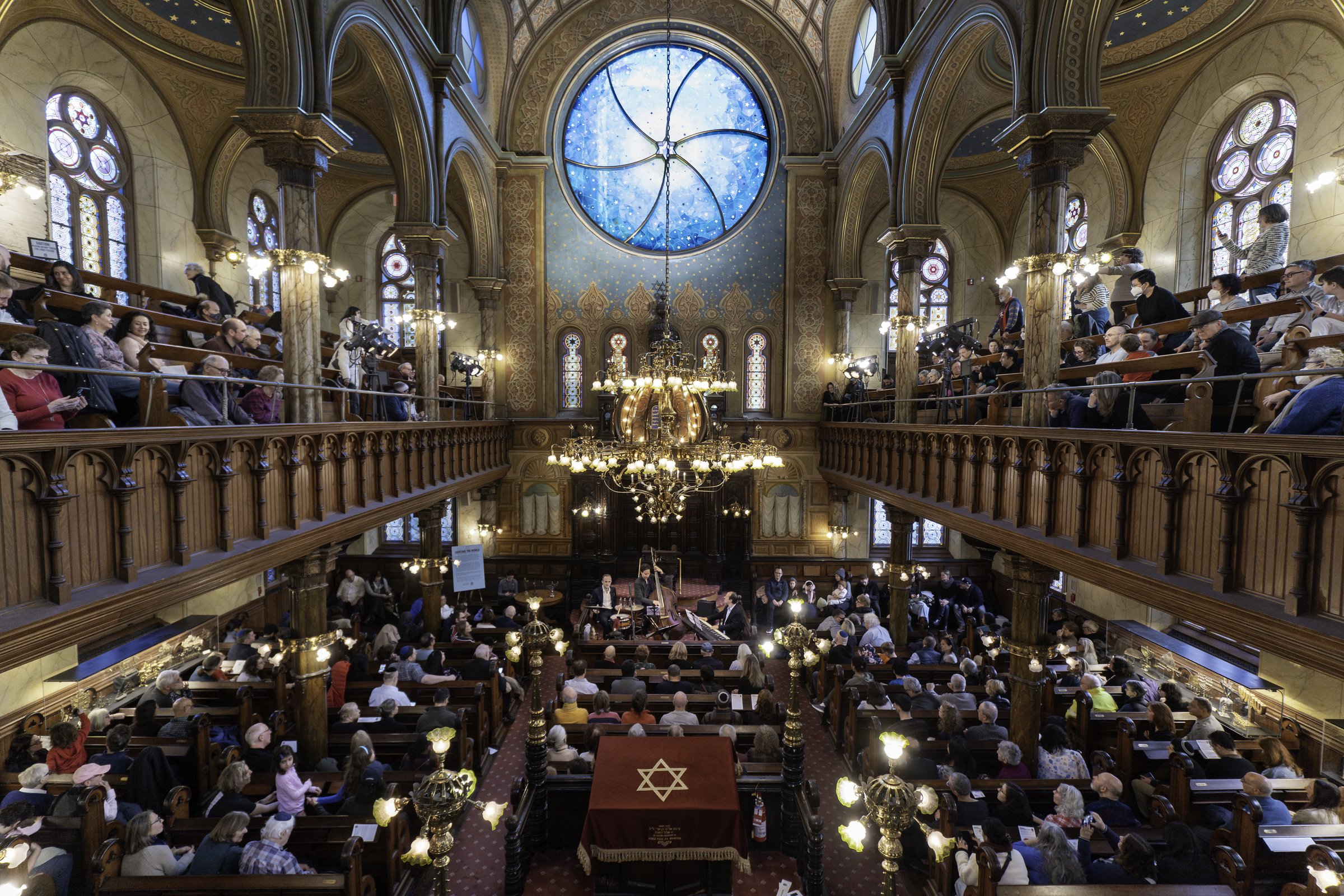 The restored sanctuary of the Museum at Eldridge Street, its great round window glowing above the ark