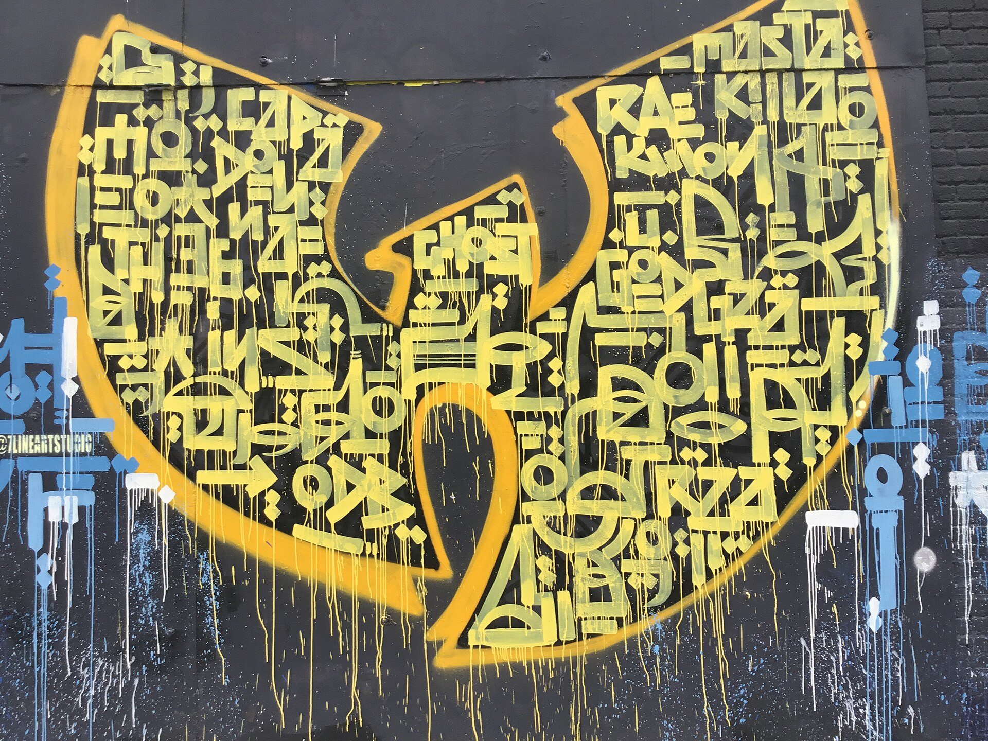 A large yellow-and-black lettering mural on a Bushwick Collective wall in Bushwick, Brooklyn