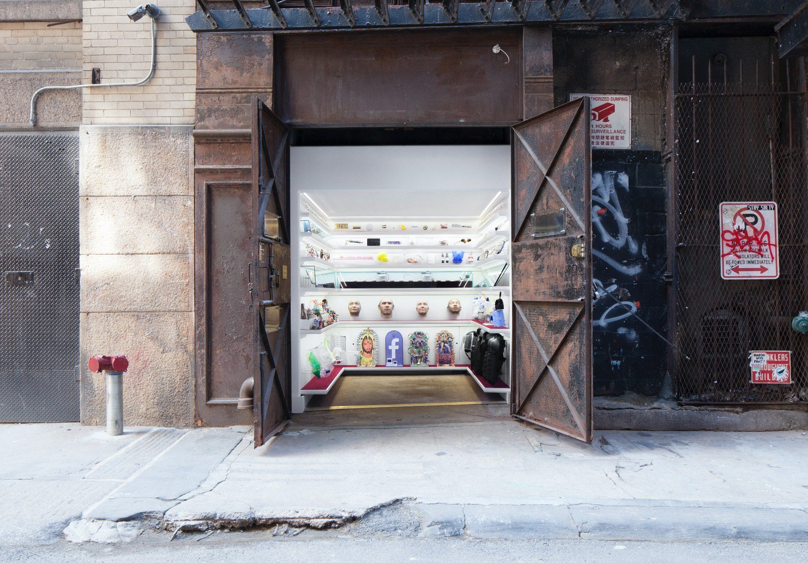 Mmuseumm's open steel doors in Cortlandt Alley, revealing lit shelves of objects inside a former freight elevator
