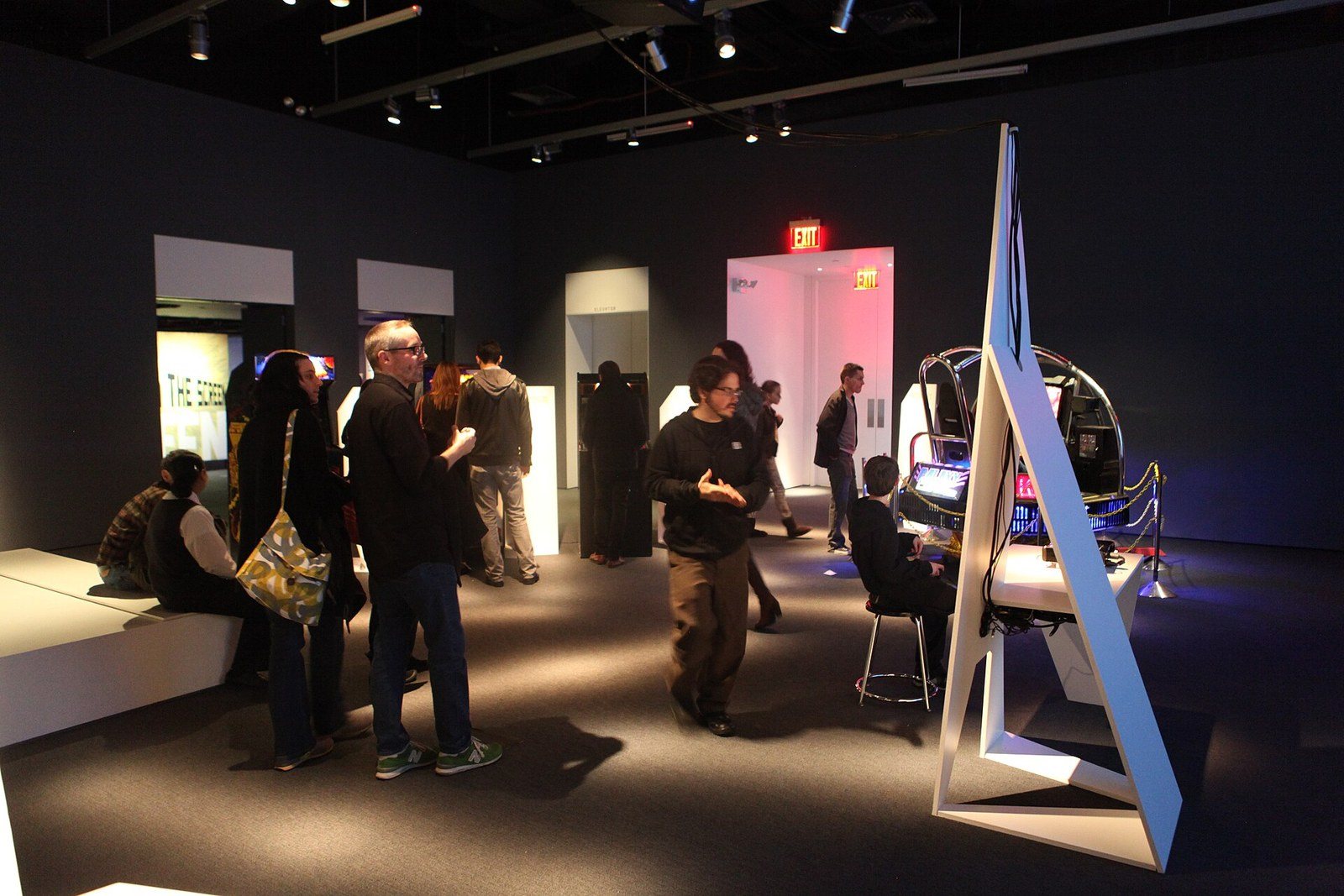 Visitors exploring an exhibition gallery of screens and installations at the Museum of the Moving Image