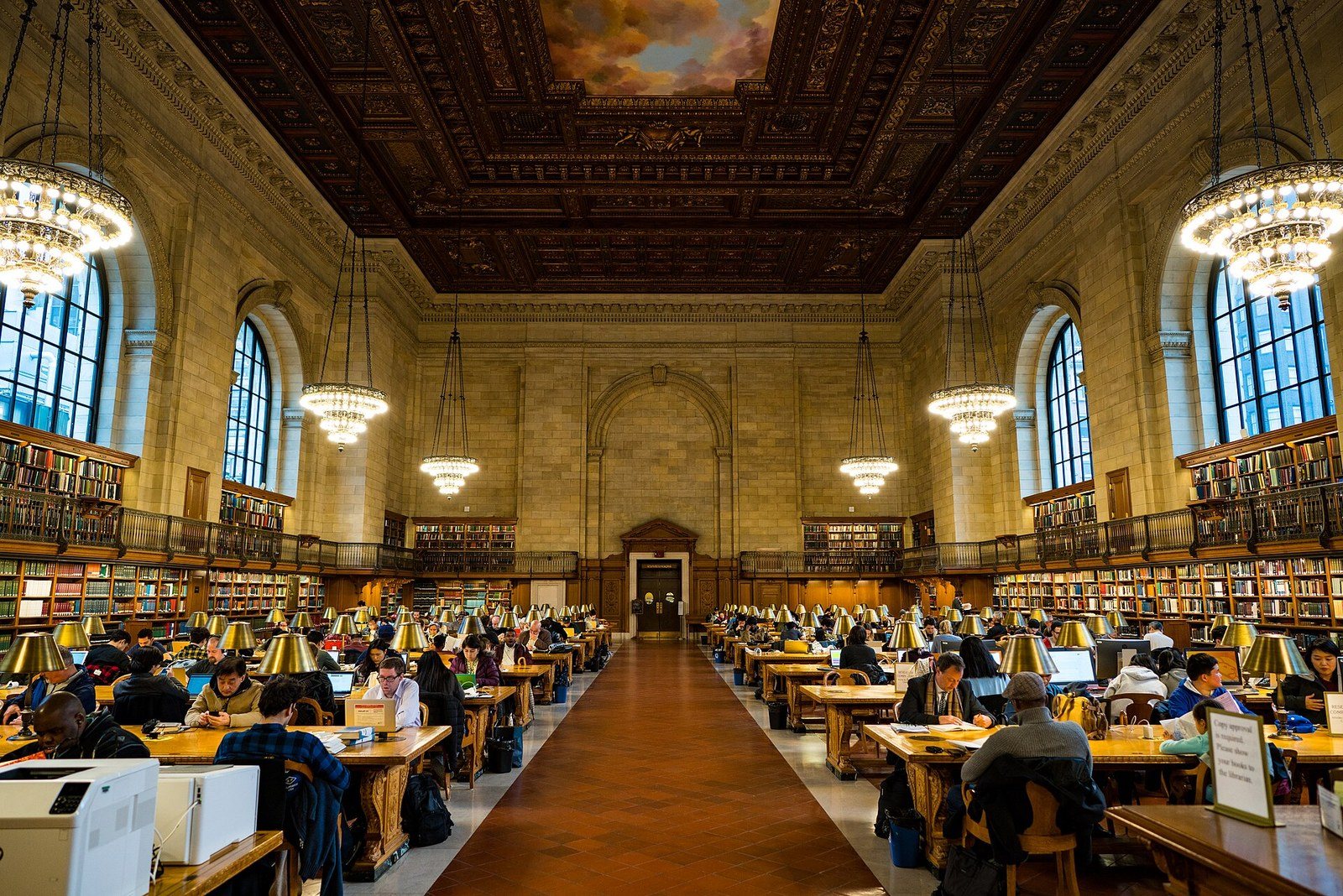 The Rose Main Reading Room, with readers at long wooden tables under chandeliers and a painted ceiling