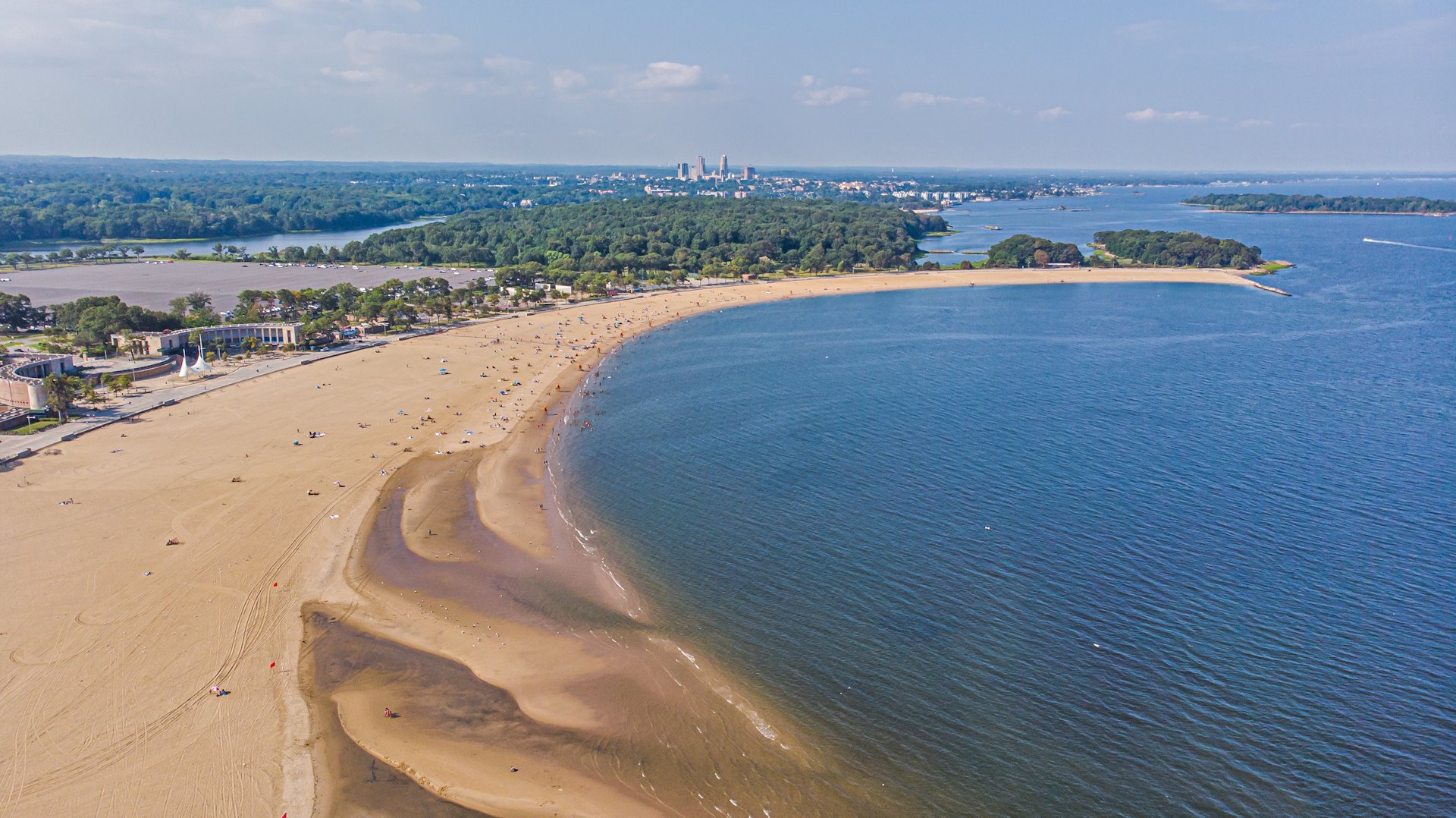 Orchard Beach's long crescent of sand in Pelham Bay Park, seen from above on Long Island Sound