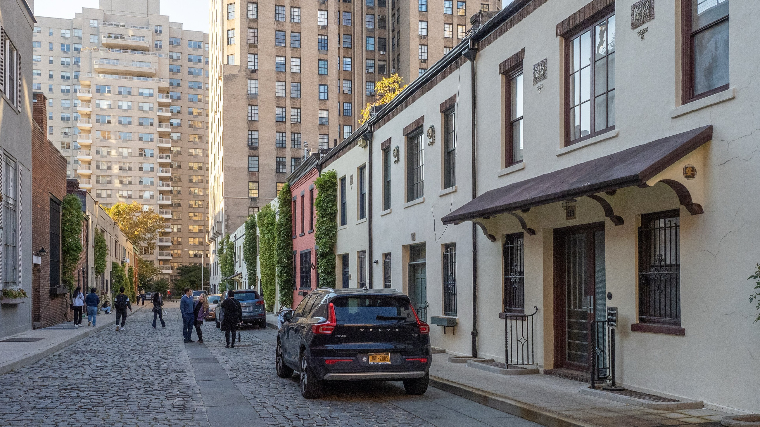 Cobblestone lane of Washington Mews lined with low converted stable houses and climbing vines