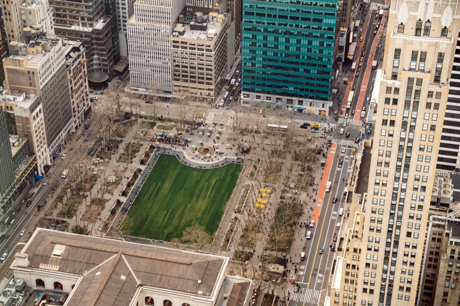 Bryant Park's lawn and plane-tree allées with midtown towers rising on all sides