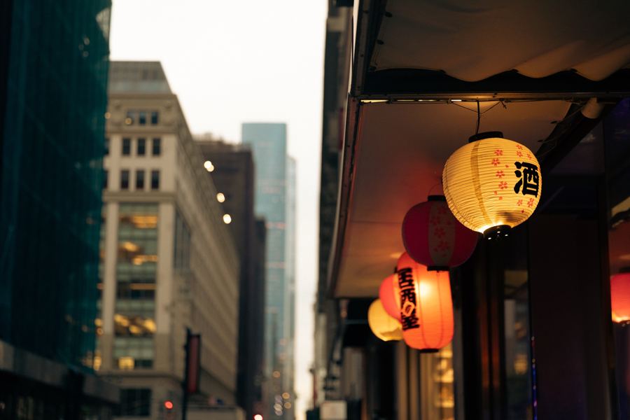 The curved stretch of Doyers Street in Chinatown at dusk, storefront signs lit along the narrow bend