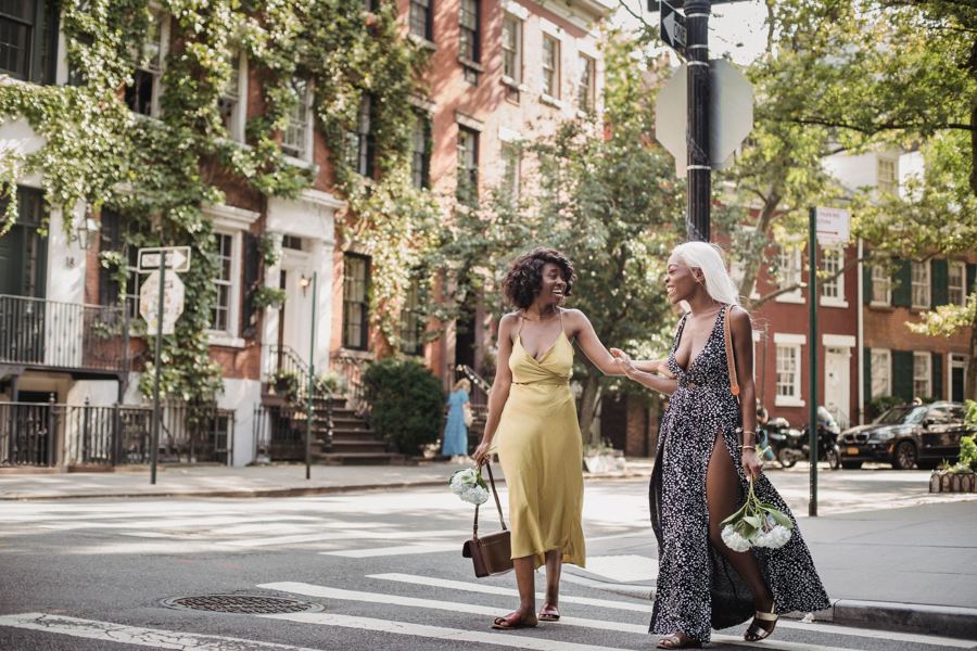 Two people strolling down a tree-lined city street