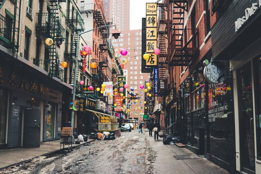Tenement buildings with fire escapes on a narrow downtown street