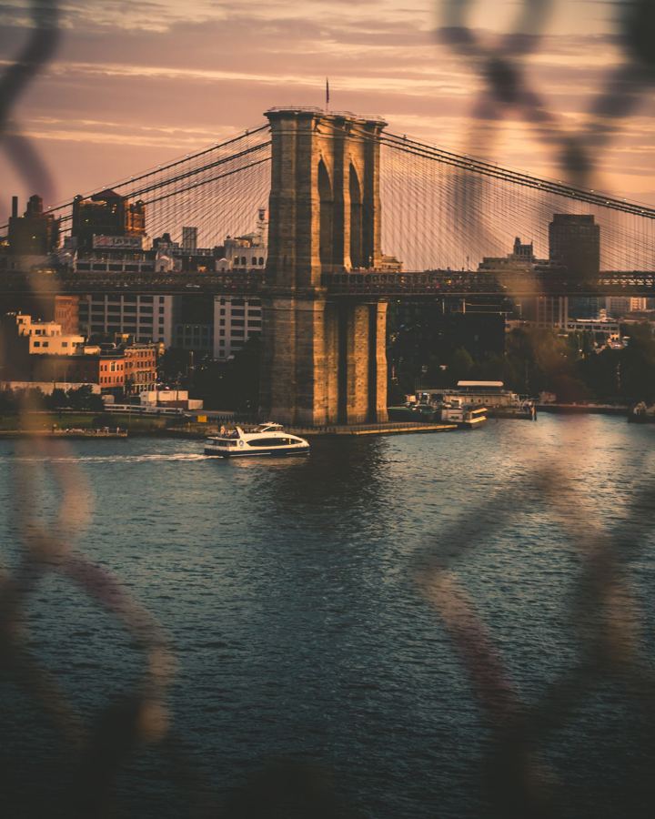 The Brooklyn Bridge glowing at golden hour over the East River