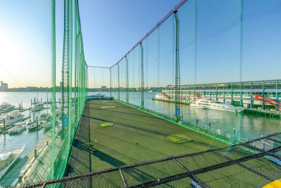 The range from above in daylight, its green netting running out over the Hudson past the Chelsea Piers marina