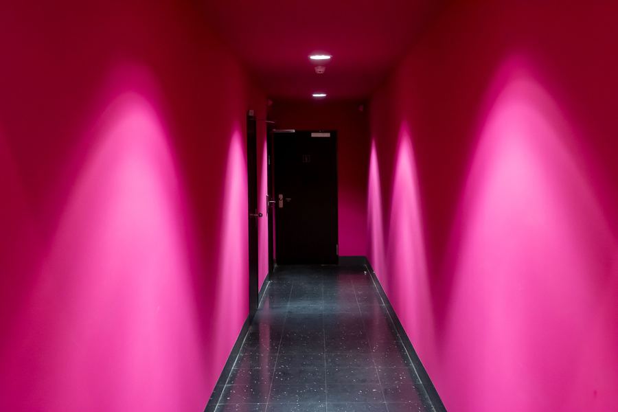 A corridor washed in magenta light