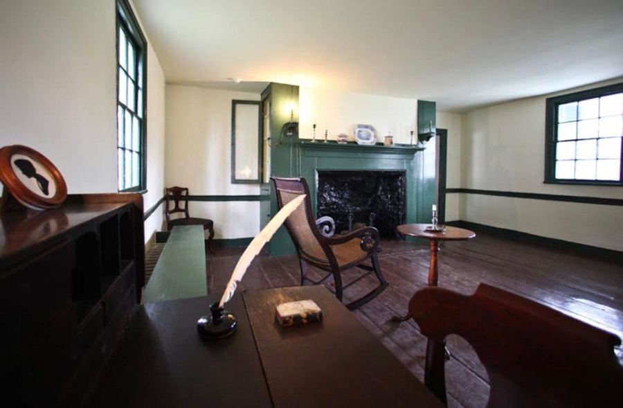The parlor at Poe Cottage, with a writing desk and quill by the window