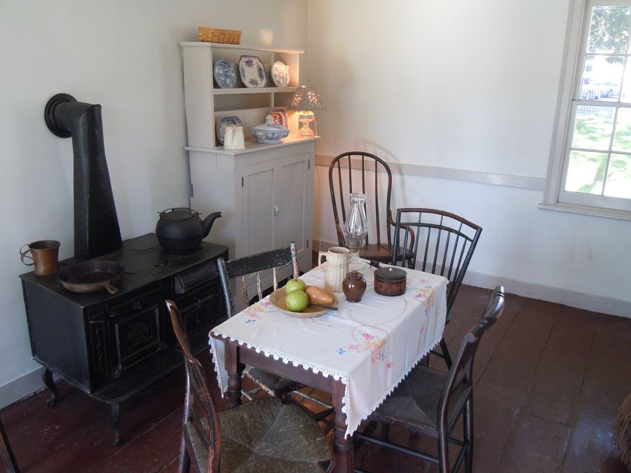 The kitchen at Poe Cottage, with its iron stove and a table laid with pears