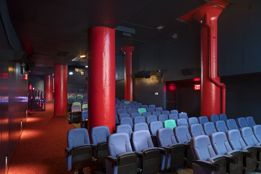 Rows of lavender seats between red columns in one of Film Forum's theaters