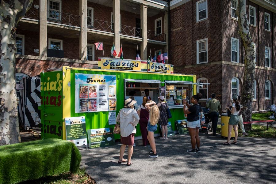 A line at a food stand on Liggett Terrace, beside the island's old red-brick barracks