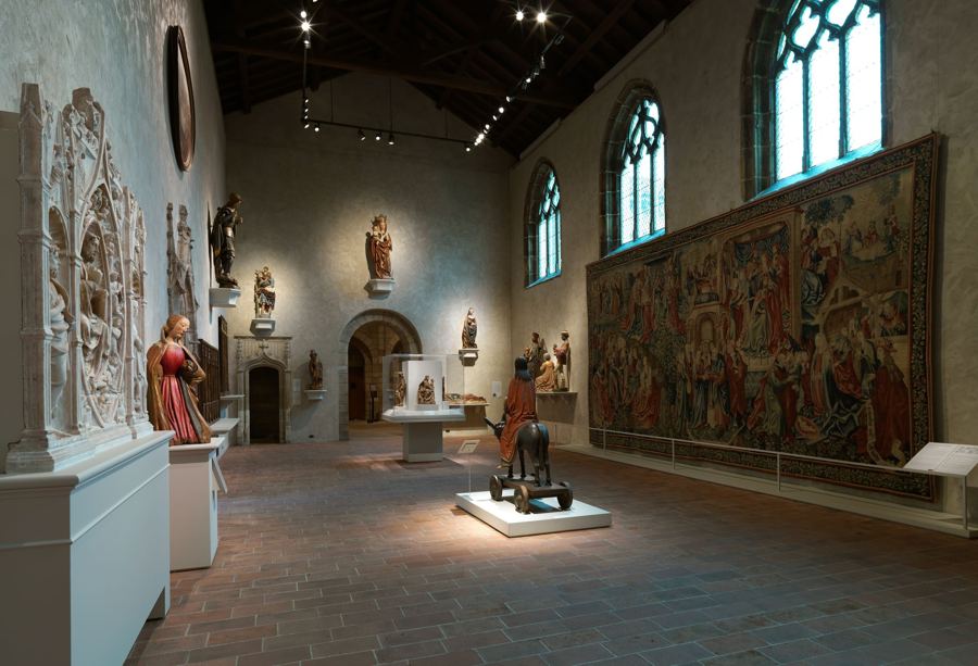 The Late Gothic Hall, with a large tapestry, sculpture and tall windows