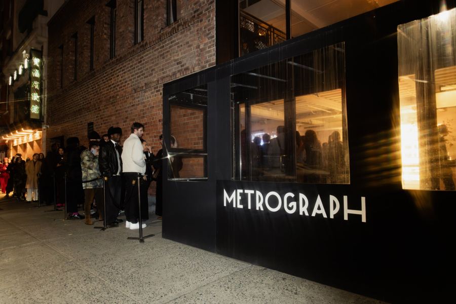 The illuminated Metrograph sign at night, guests gathered by the entrance