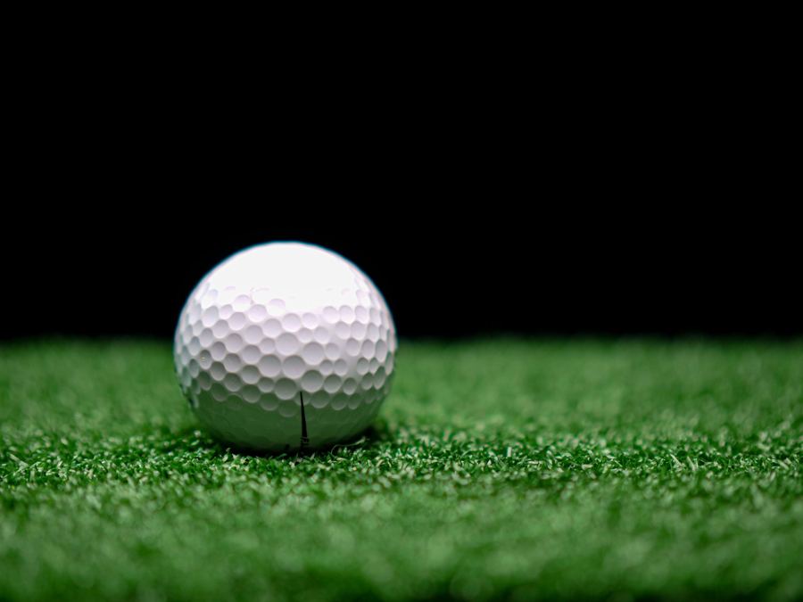 A golf ball on a putting green under a spotlight