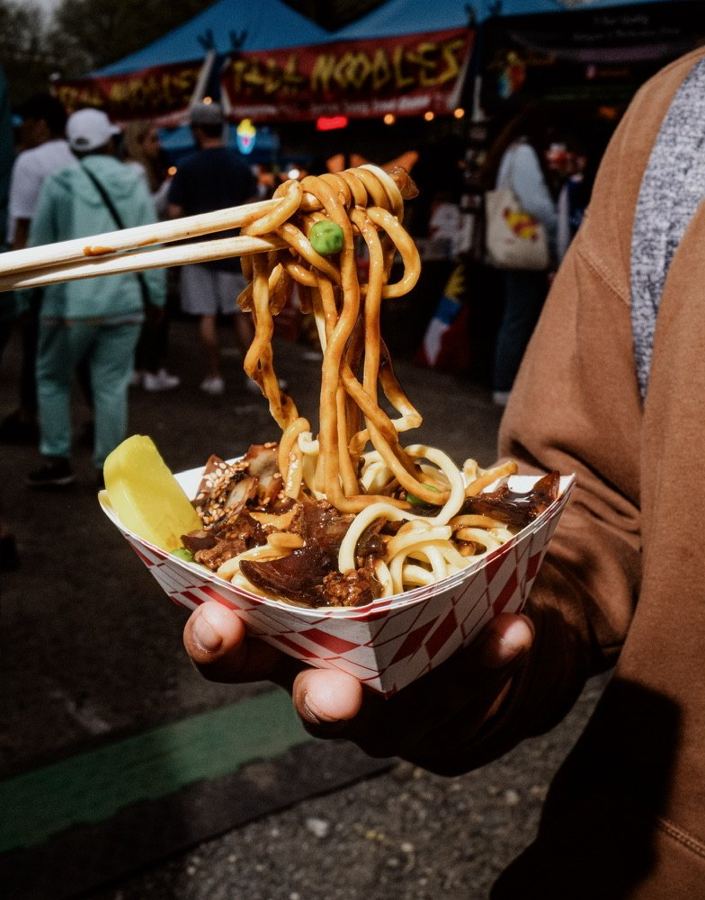 Hand-pulled noodles lifted from a bowl at the Queens Night Market