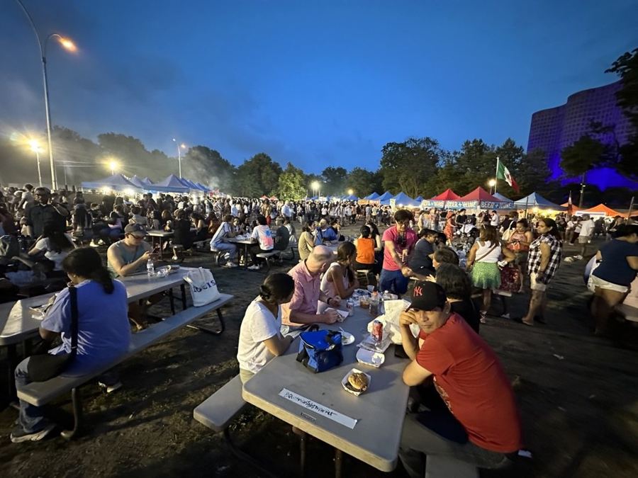 Picnic tables full after dark at the Queens Night Market