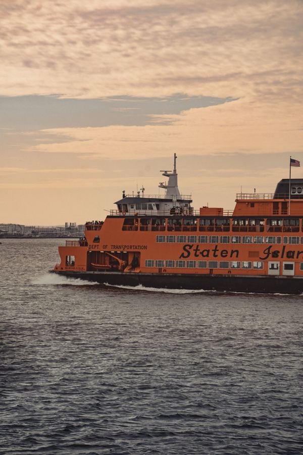 A Staten Island Ferry crossing the harbor at sunset
