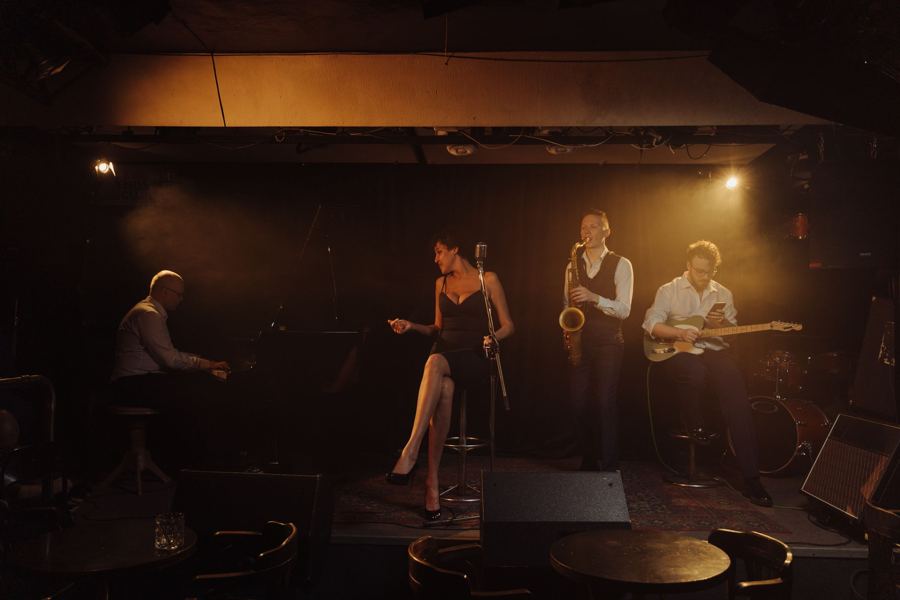 A small band on a candlelit club stage
