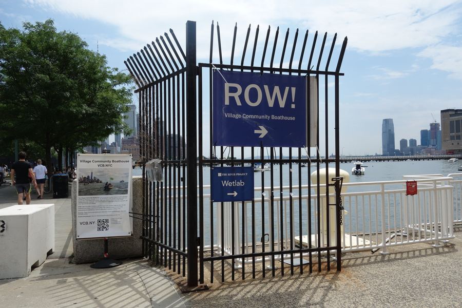 The 'ROW!' sign for the Village Community Boathouse on Pier 40, the Hudson and Jersey City beyond