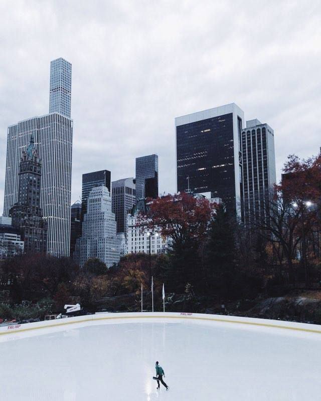 A lone skater on Wollman Rink below Midtown towers