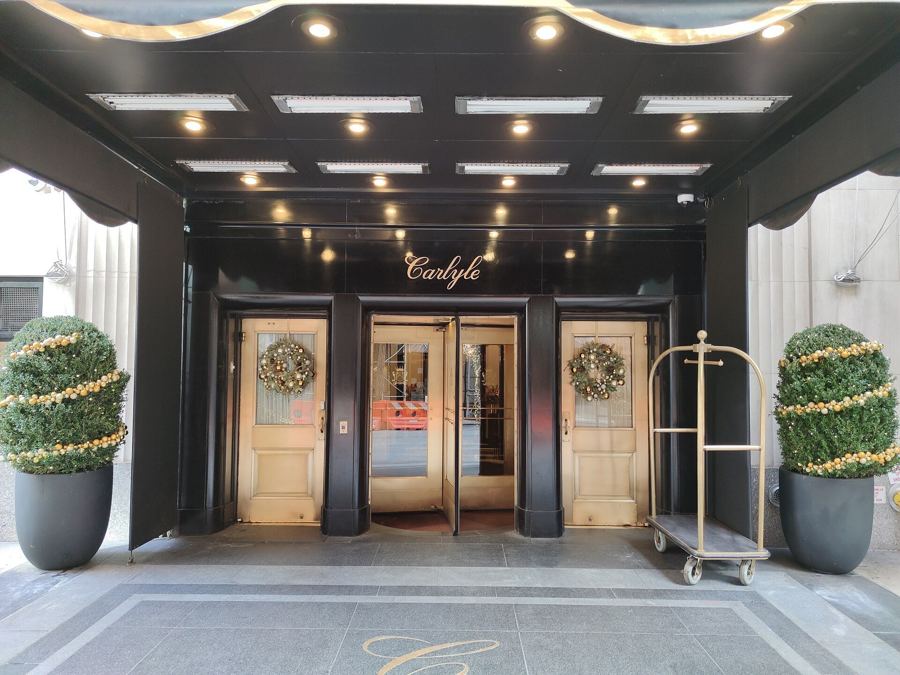 The canopied East 76th Street entrance of the Carlyle hotel, home of Café Carlyle, with potted topiaries and holiday wreaths