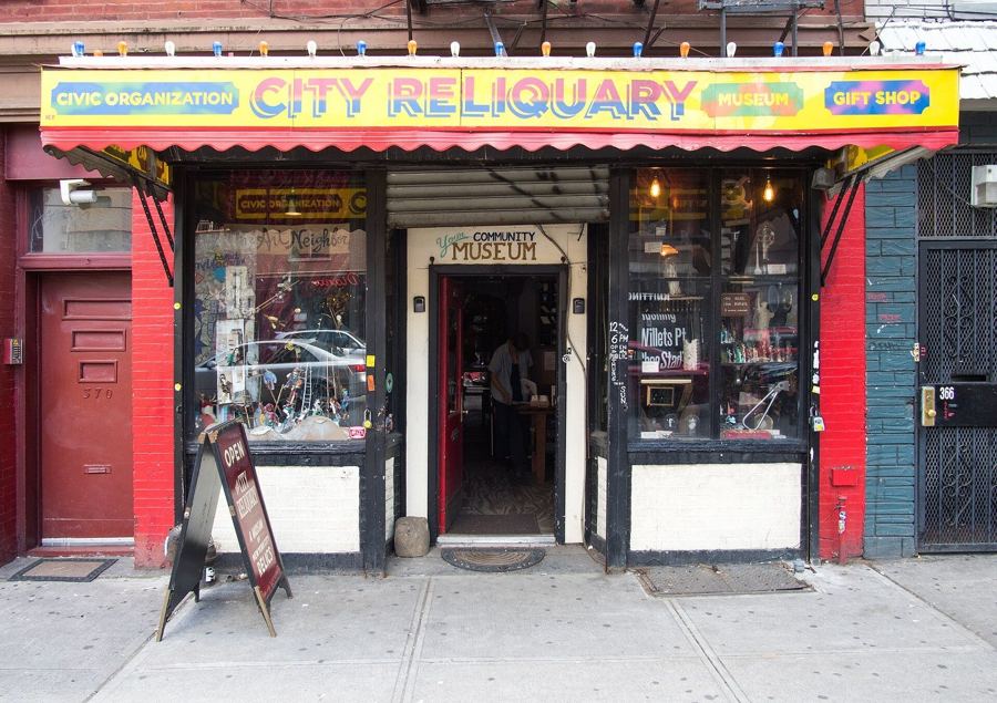 The City Reliquary's storefront on Metropolitan Avenue, with its painted sign and windows packed with objects