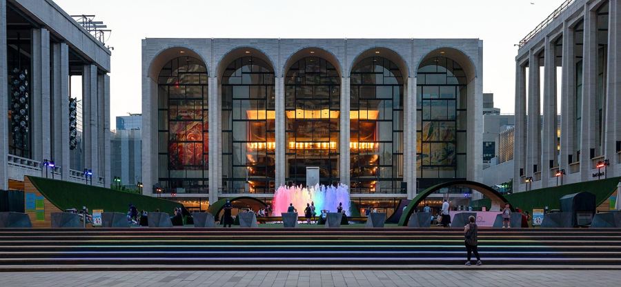 Lincoln Center's plaza at dusk, with the fountain lit and the Metropolitan Opera House glowing behind