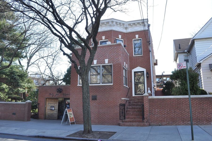 The brick facade of the Louis Armstrong House on a residential street in Corona, Queens