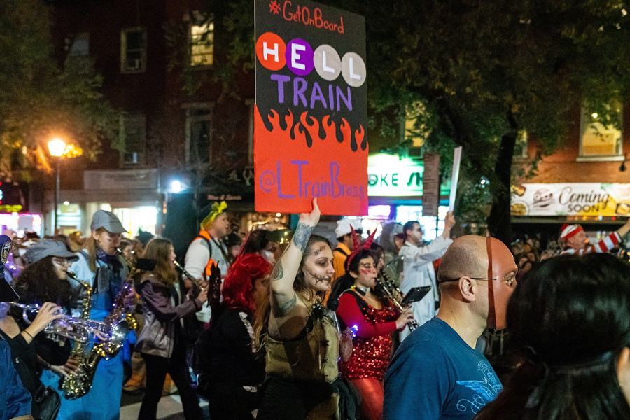 Costumed marchers and a brass band fill Sixth Avenue during the 2019 Village Halloween Parade