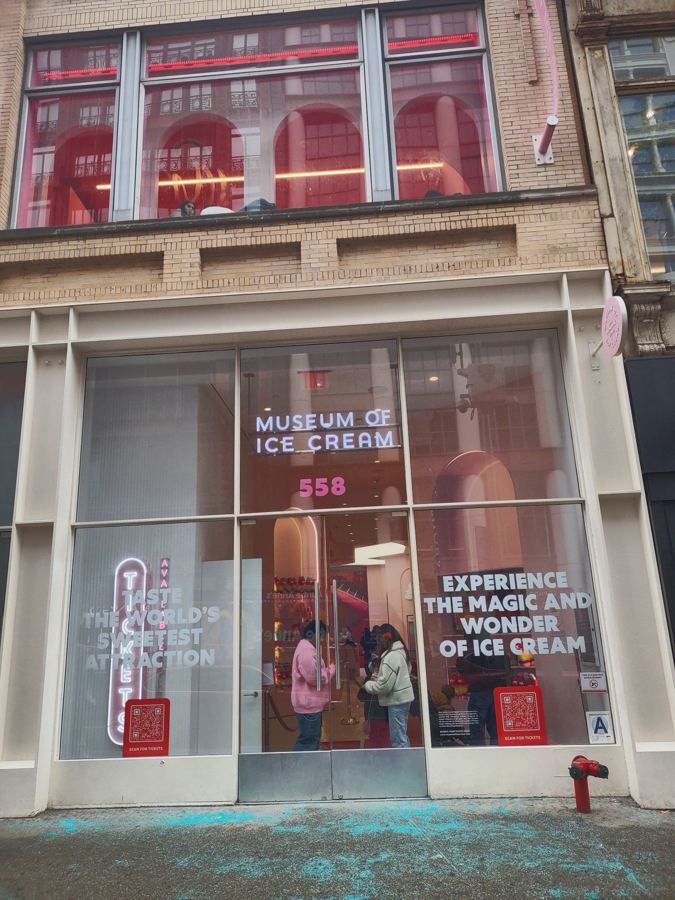 The glass storefront of the Museum of Ice Cream at 558 Broadway in SoHo, with its neon name sign and pink displays inside
