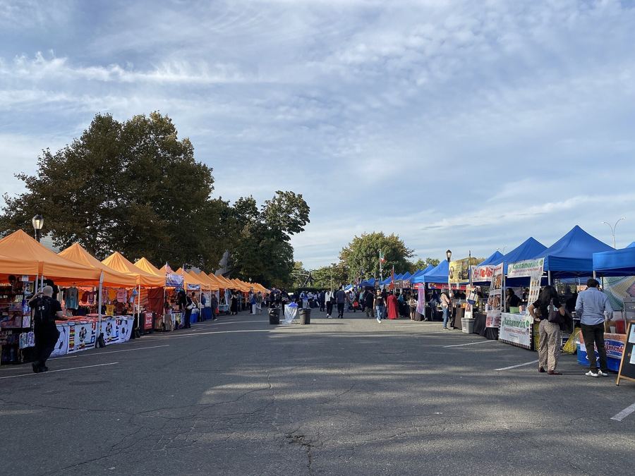 Rows of vendor tents at the Queens Night Market in Flushing Meadows Corona Park at opening hour, October 2026