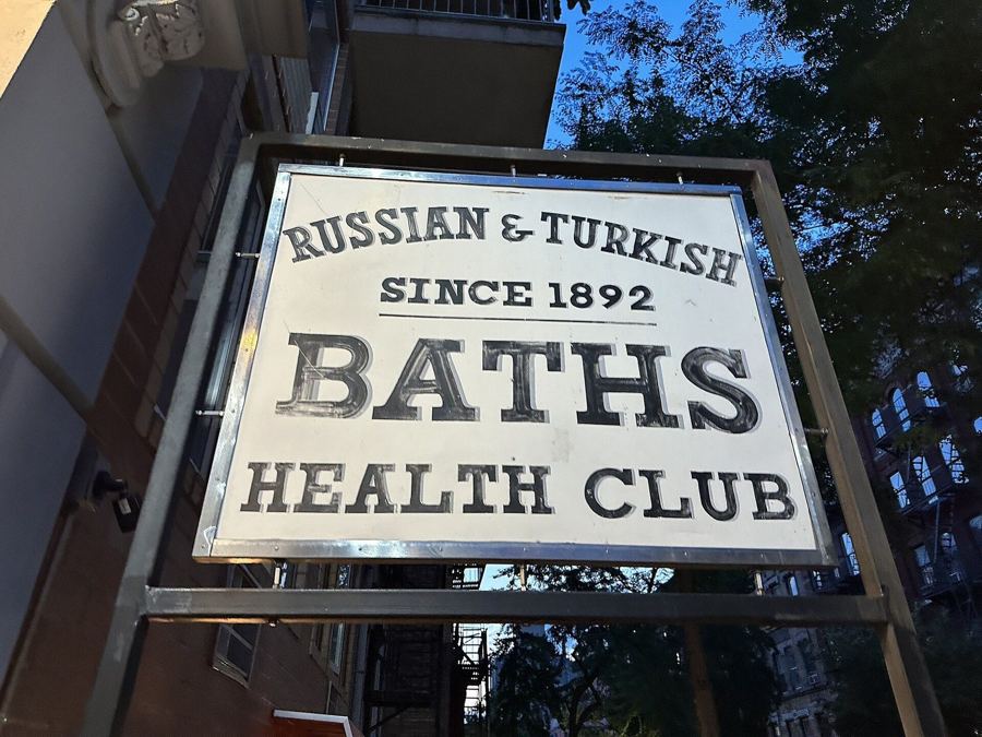 The 'Russian & Turkish Baths, Since 1892, Health Club' sign hanging over the entrance on East 10th Street