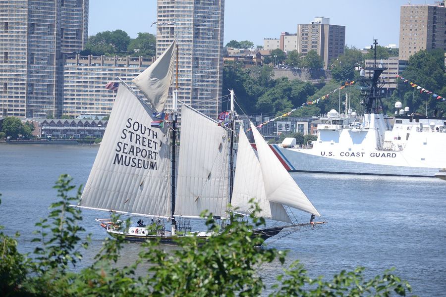 The schooner Pioneer under sail on the Hudson during Sail250 in July 2026, with the Coast Guard and New Jersey shore behind