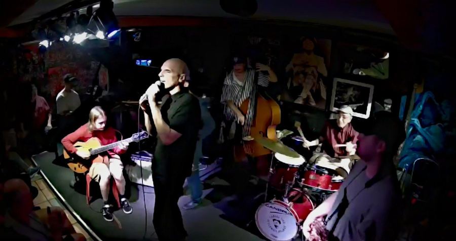 A quartet playing on the small, crowded bandstand inside Smalls Jazz Club, photographed from the audience in 2025