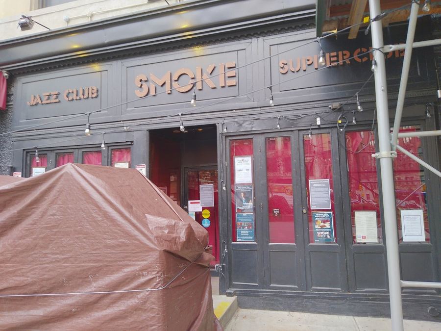 The dark-painted facade of Smoke Jazz & Supper Club on Broadway, with its name across the top