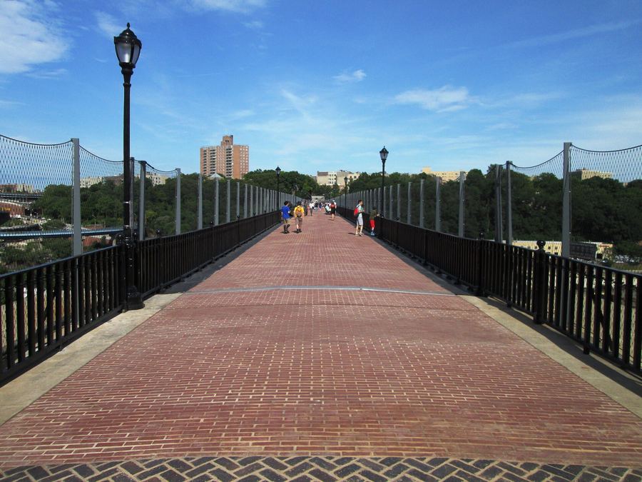 The brick walkway of the High Bridge stretching toward the Bronx, with lampposts and safety fencing on either side