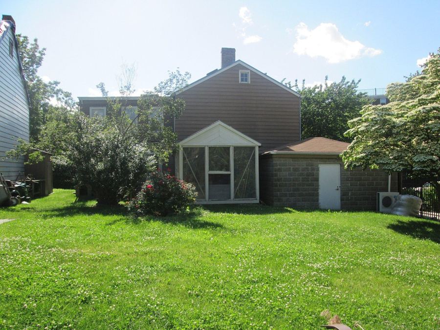 One of the historic Hunterfly Road Houses at Weeksville, a small wooden house set back on a green lawn