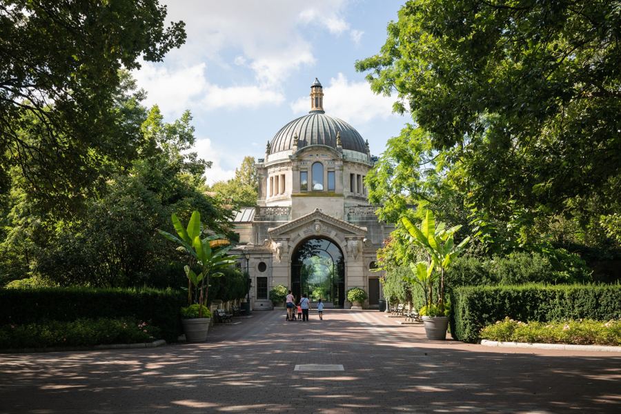 The Beaux-Arts Zoo Center at the Bronx Zoo, its dome framed by trees at the end of a garden walk