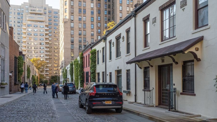 Cobblestone lane of Washington Mews lined with low converted stable houses and climbing vines