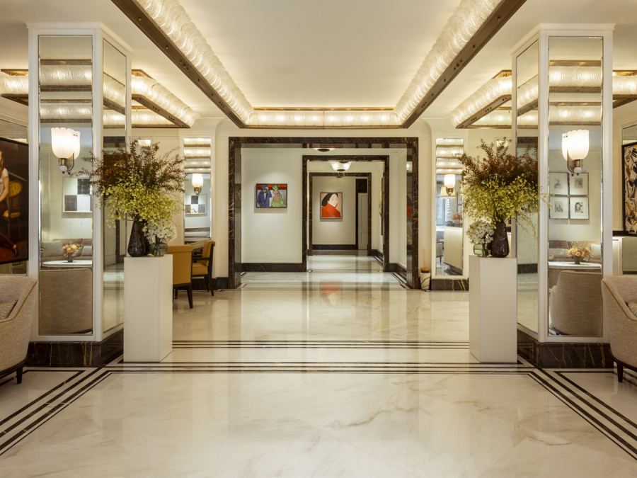 The Surrey's marble lobby, with mirrored columns, potted orchids and a glowing coffered ceiling