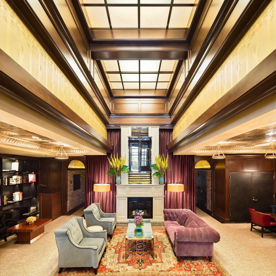 The main lobby at Walker Hotel Greenwich Village, with a fireplace and coffered ceiling